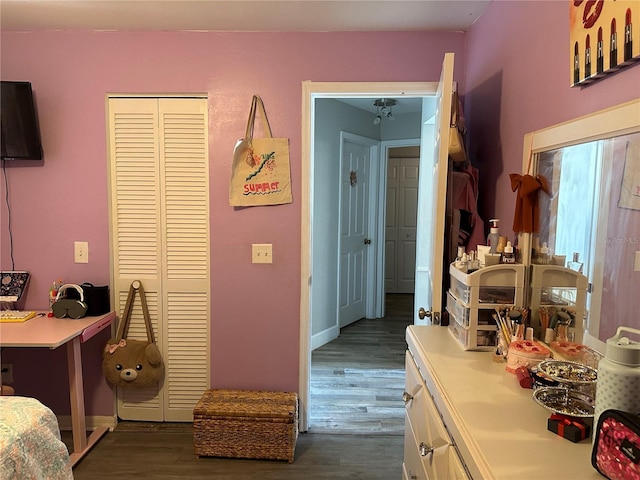 bedroom with dark wood-type flooring and a closet