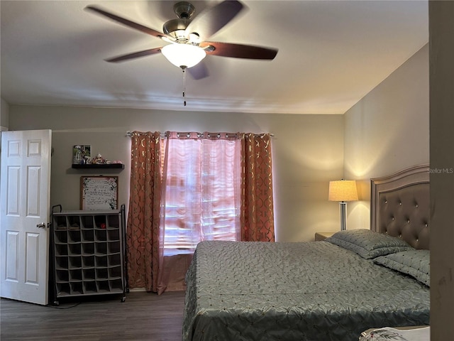 bedroom with dark hardwood / wood-style flooring and ceiling fan