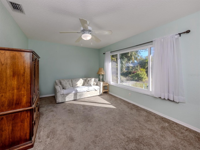 unfurnished room featuring ceiling fan, light colored carpet, and a textured ceiling