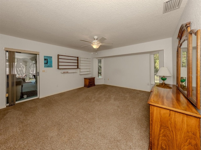 living room with ceiling fan, a textured ceiling, and carpet