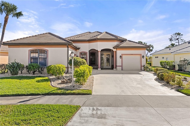 mediterranean / spanish-style home featuring a front lawn and a garage