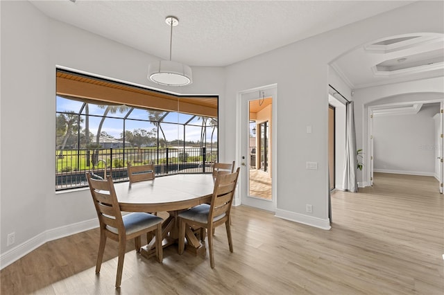 dining space with a textured ceiling and light hardwood / wood-style floors