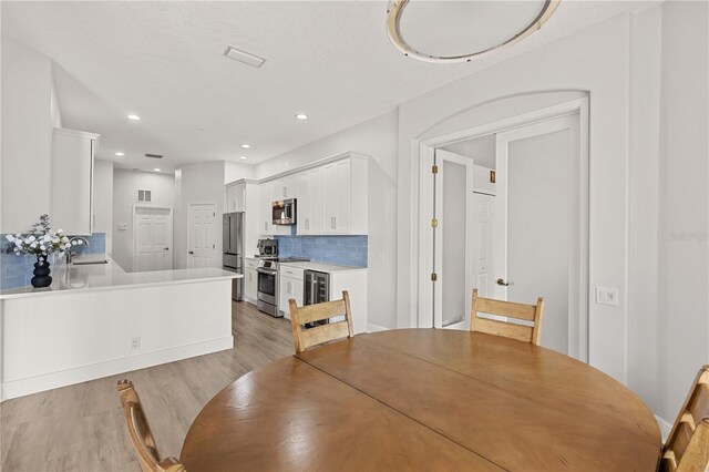 dining area with sink and light hardwood / wood-style floors