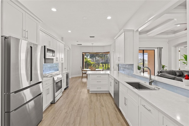 kitchen with white cabinets, kitchen peninsula, sink, and appliances with stainless steel finishes