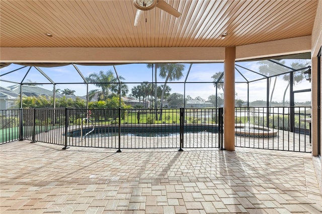 view of patio featuring glass enclosure and ceiling fan