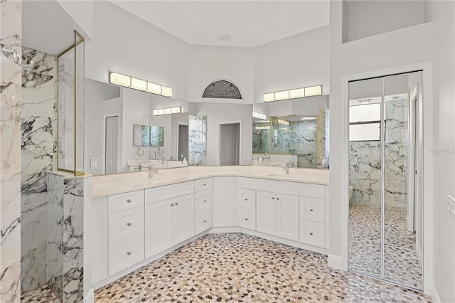 bathroom with tiled shower and vanity