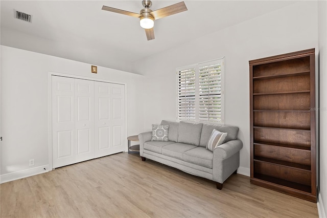 living room featuring light wood-type flooring and ceiling fan