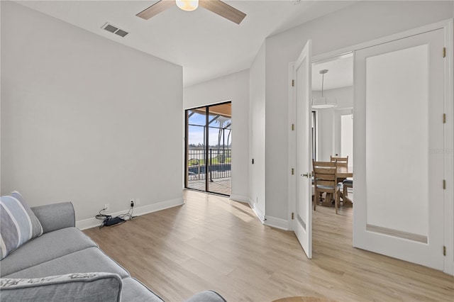 living room with ceiling fan and light wood-type flooring