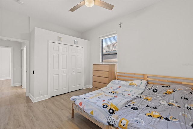 bedroom featuring ceiling fan, light hardwood / wood-style flooring, and a closet