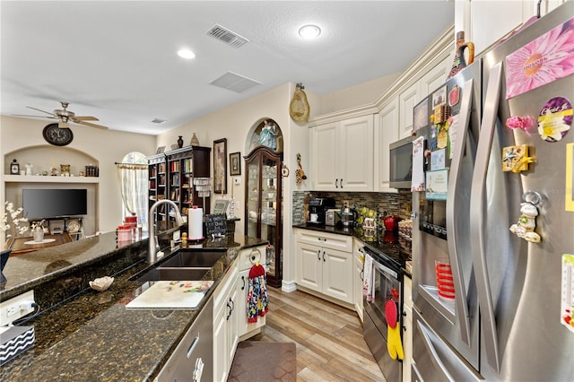 kitchen featuring dark stone countertops, sink, white cabinetry, and stainless steel appliances