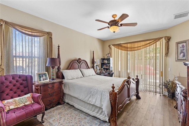 bedroom featuring multiple windows, access to exterior, light hardwood / wood-style flooring, and ceiling fan