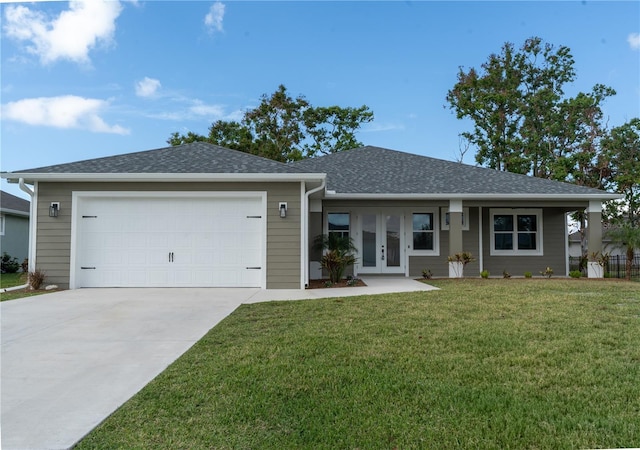 ranch-style home with a garage, a front yard, and french doors