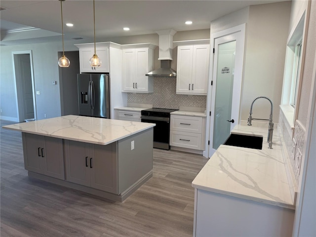 kitchen with electric range oven, a center island, white cabinets, stainless steel fridge with ice dispenser, and wall chimney exhaust hood