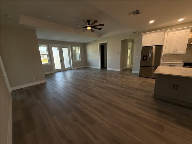 kitchen featuring white cabinets, french doors, dark hardwood / wood-style flooring, stainless steel fridge with ice dispenser, and a raised ceiling