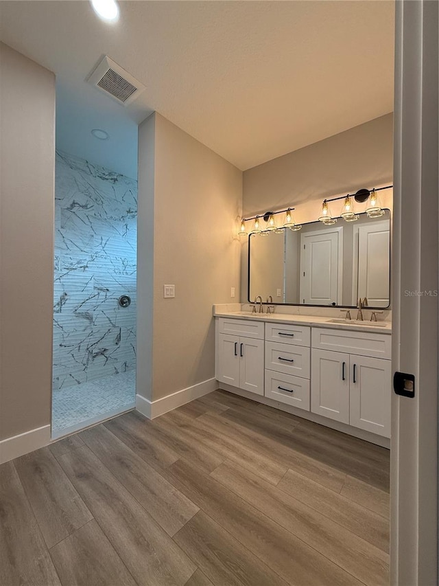 bathroom with vanity, wood-type flooring, and a shower