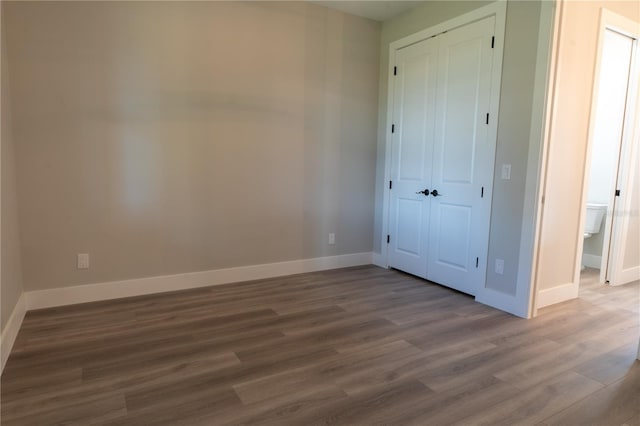 unfurnished bedroom featuring wood-type flooring and a closet