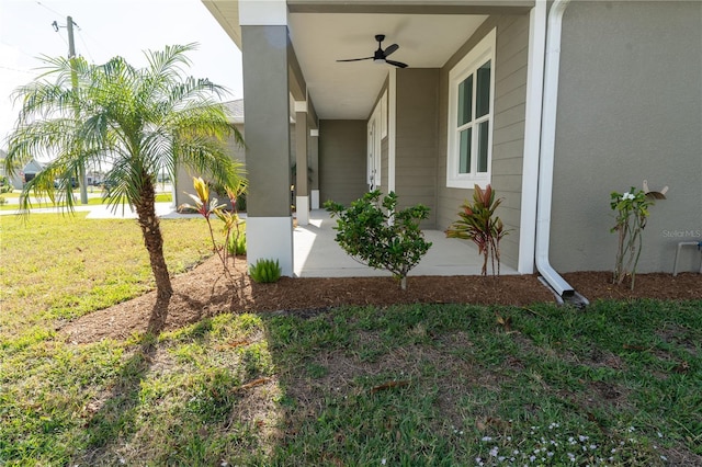 property entrance with a lawn and ceiling fan