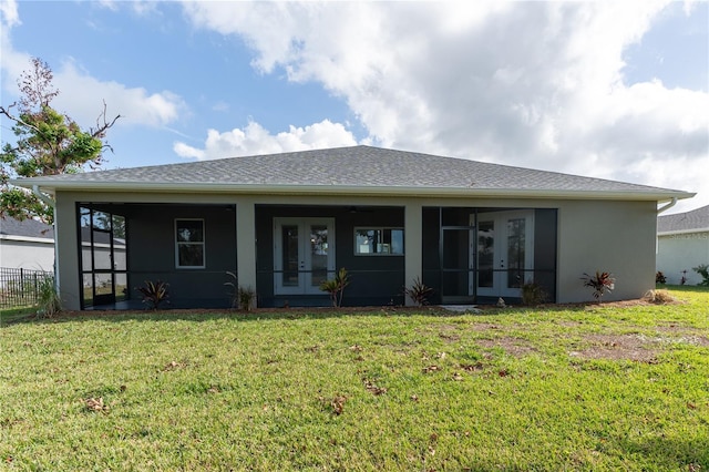 rear view of property featuring a lawn and french doors