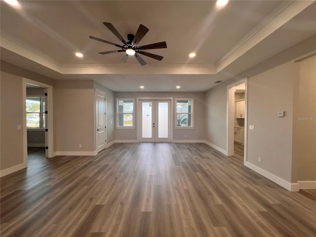 unfurnished living room with dark wood-type flooring, ceiling fan, ornamental molding, french doors, and a raised ceiling