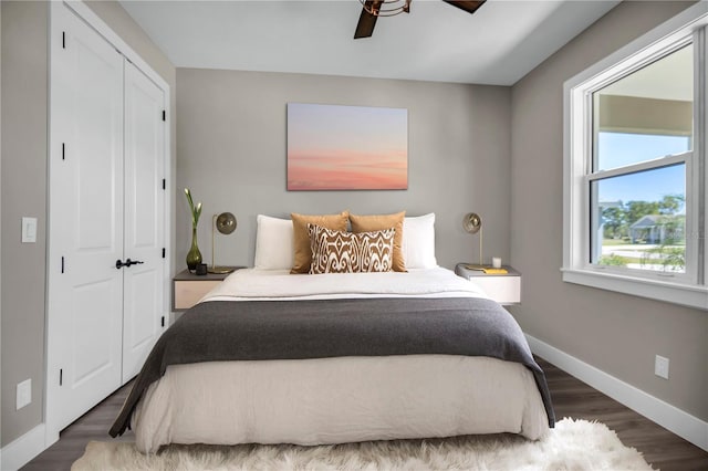 bedroom featuring ceiling fan, a closet, baseboards, and wood finished floors