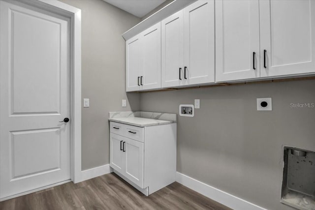 laundry area featuring hookup for a washing machine, cabinet space, hookup for an electric dryer, wood finished floors, and baseboards