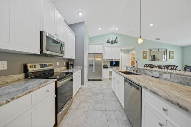 kitchen with light stone counters, decorative light fixtures, lofted ceiling, white cabinetry, and appliances with stainless steel finishes