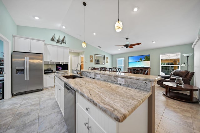 kitchen featuring stainless steel appliances, a center island with sink, white cabinets, and sink