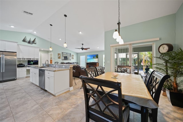 kitchen featuring a kitchen island with sink, stainless steel appliances, ceiling fan, light stone counters, and white cabinets