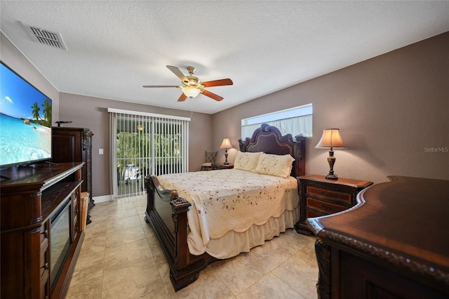 tiled bedroom with access to exterior, ceiling fan, and a textured ceiling