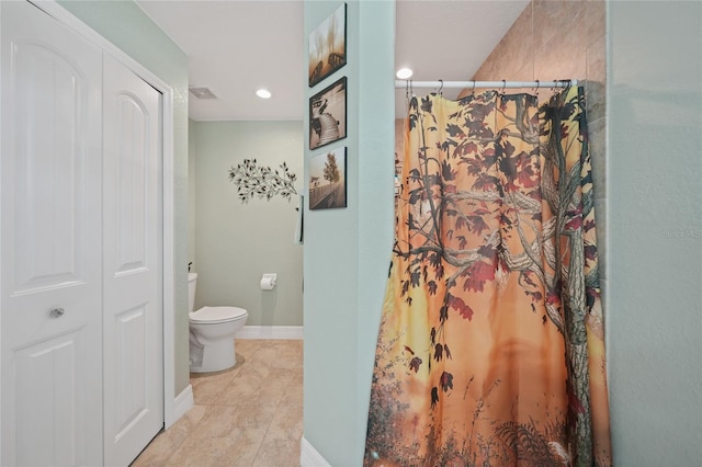 bathroom featuring toilet, a shower with shower curtain, and tile patterned flooring