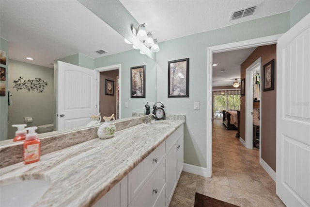 bathroom featuring toilet, vanity, and ceiling fan