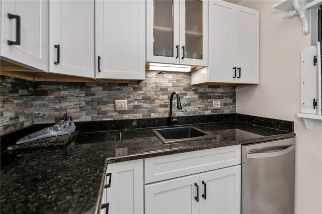 kitchen with dishwasher, sink, dark stone countertops, and white cabinetry