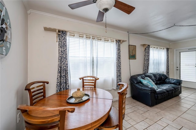 tiled dining space featuring ceiling fan and crown molding