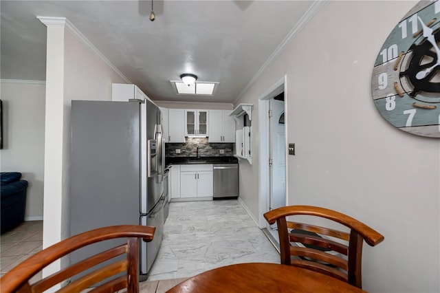 kitchen featuring crown molding, stainless steel appliances, decorative backsplash, and white cabinets