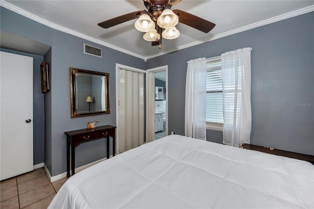 tiled bedroom with ceiling fan, crown molding, and ensuite bathroom