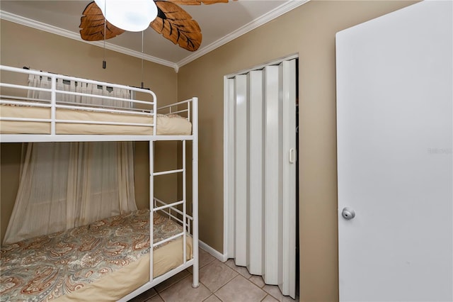 unfurnished bedroom with a closet, crown molding, tile patterned floors, and ceiling fan