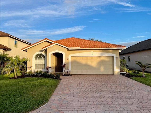 mediterranean / spanish house with a garage and a front lawn