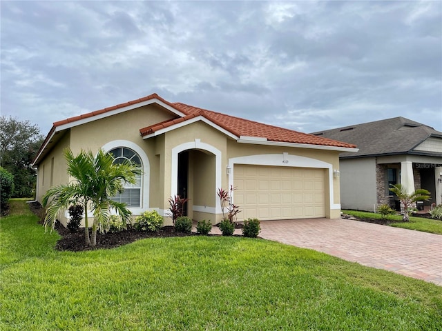 mediterranean / spanish home featuring a garage and a front yard