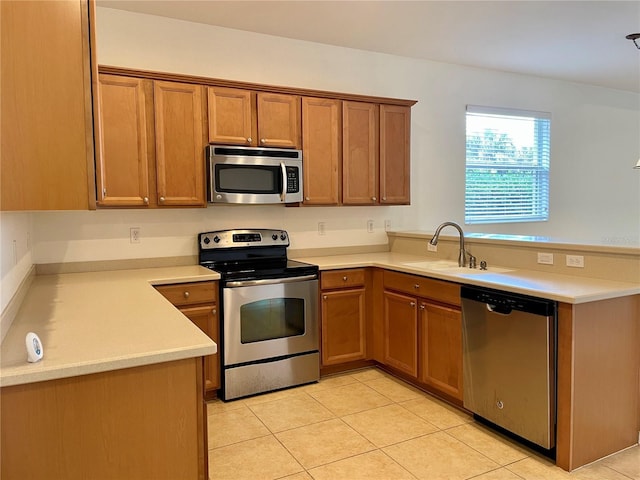 kitchen with sink, light tile patterned floors, stainless steel appliances, and kitchen peninsula