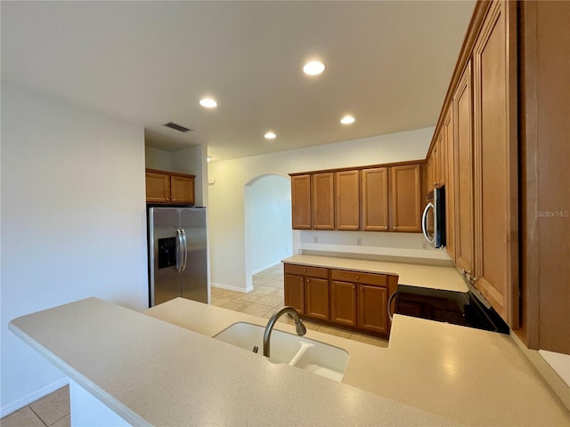 kitchen with appliances with stainless steel finishes, kitchen peninsula, and sink