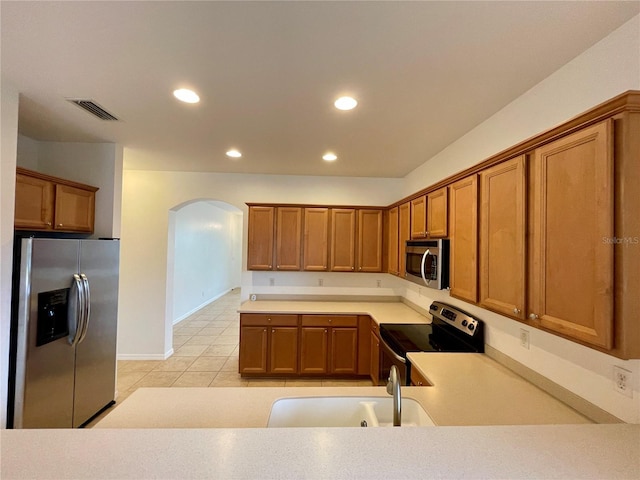 kitchen with stainless steel appliances, sink, and light tile patterned floors