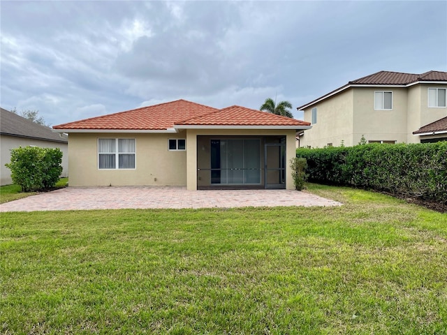 back of property featuring a patio area and a lawn