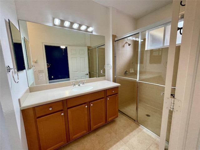 bathroom featuring tile patterned flooring, vanity, and walk in shower