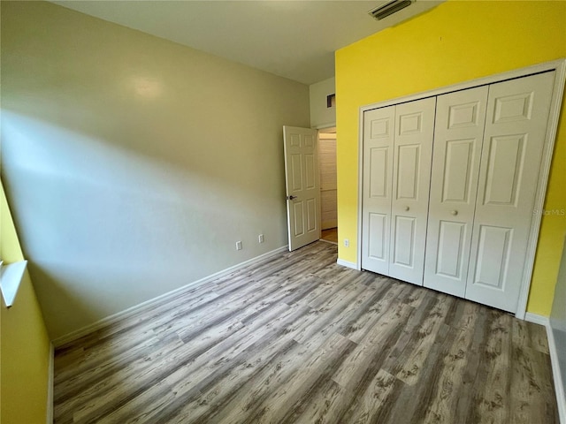 unfurnished bedroom with hardwood / wood-style flooring and a closet