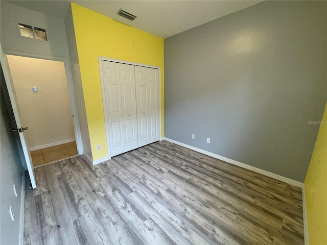 unfurnished bedroom with light hardwood / wood-style floors and a closet