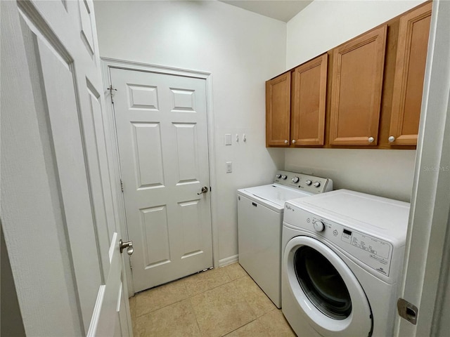 laundry area with cabinets, independent washer and dryer, and light tile patterned flooring