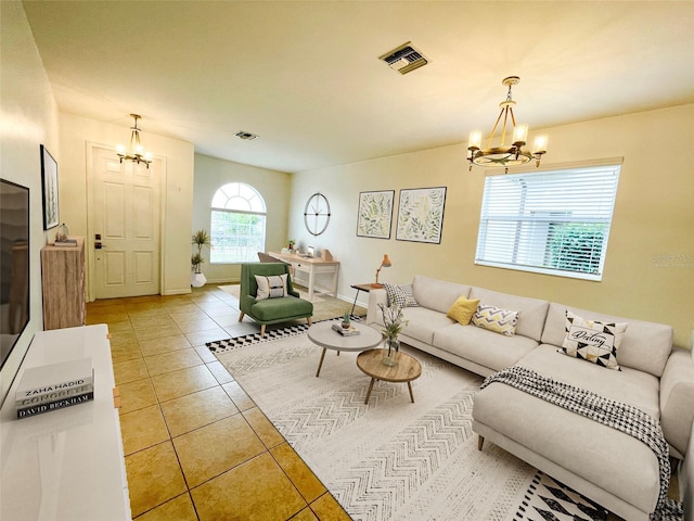 tiled living room with a notable chandelier