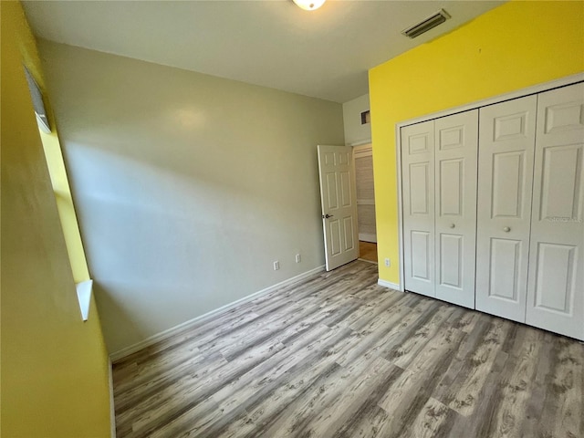 unfurnished bedroom with light hardwood / wood-style floors and a closet