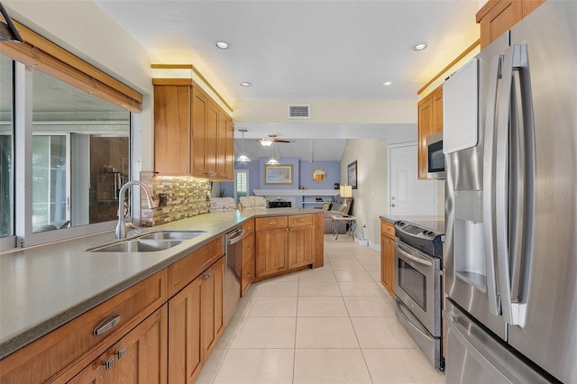 kitchen featuring kitchen peninsula, hanging light fixtures, appliances with stainless steel finishes, ceiling fan, and sink