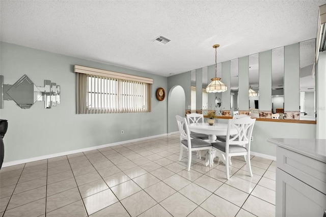 dining space with light tile patterned floors and a textured ceiling